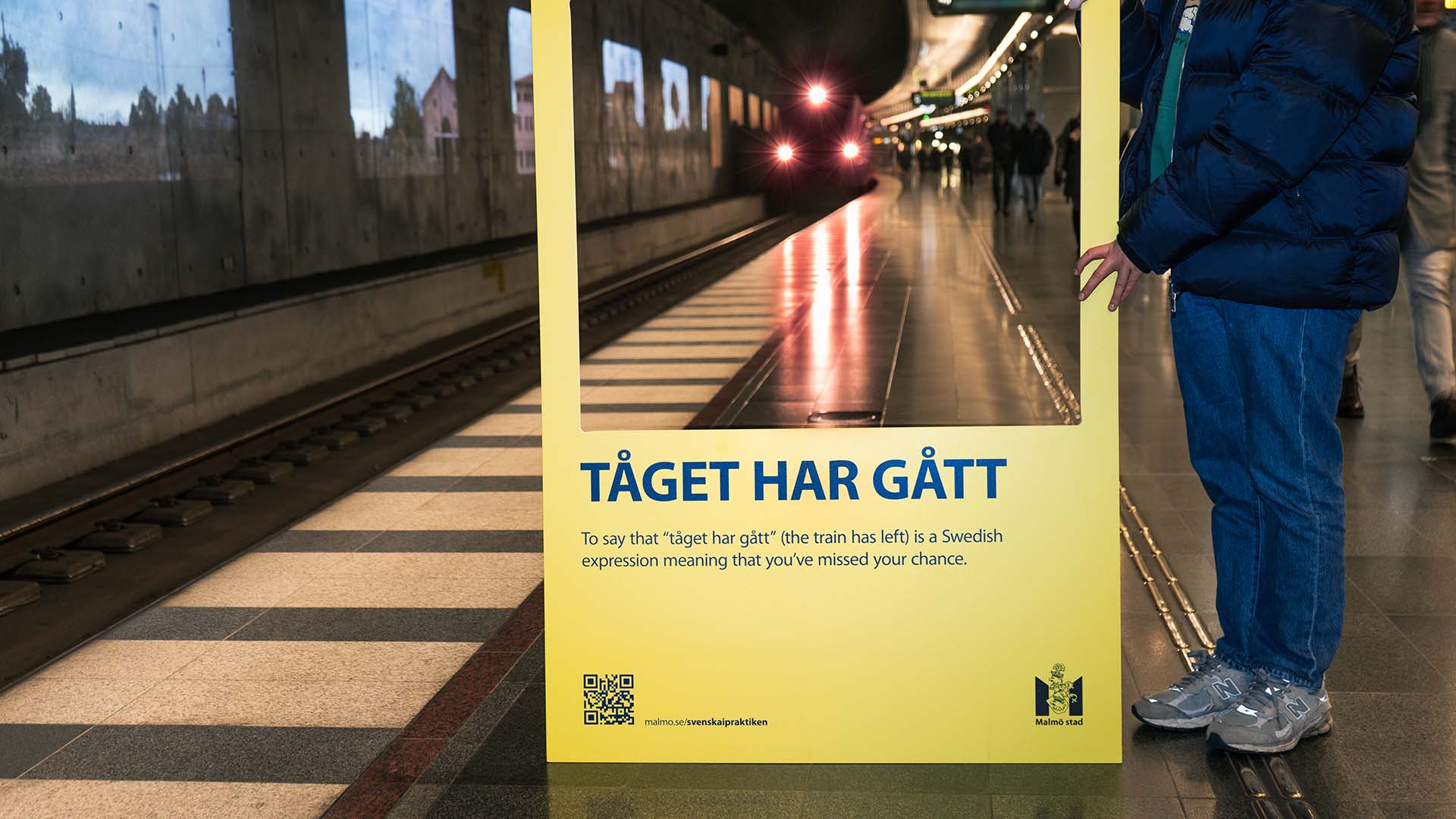 Yellow sign in a subway station showing a train approaching and Swedish text explaining 'Tåget har gått' means 'the train has left' indicating a missed chance.