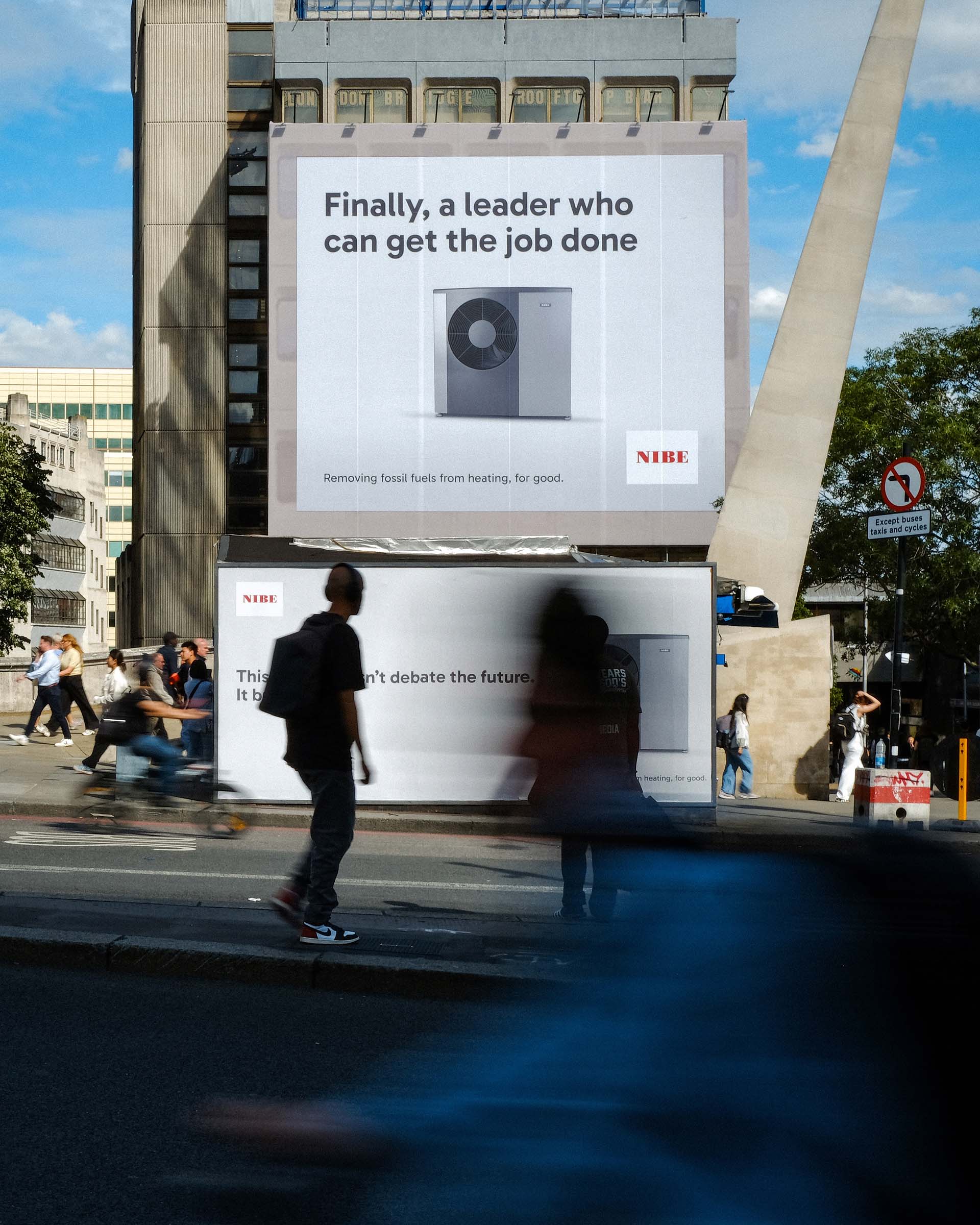 City street view with people walking past billboards advertising NIBE heating solutions.